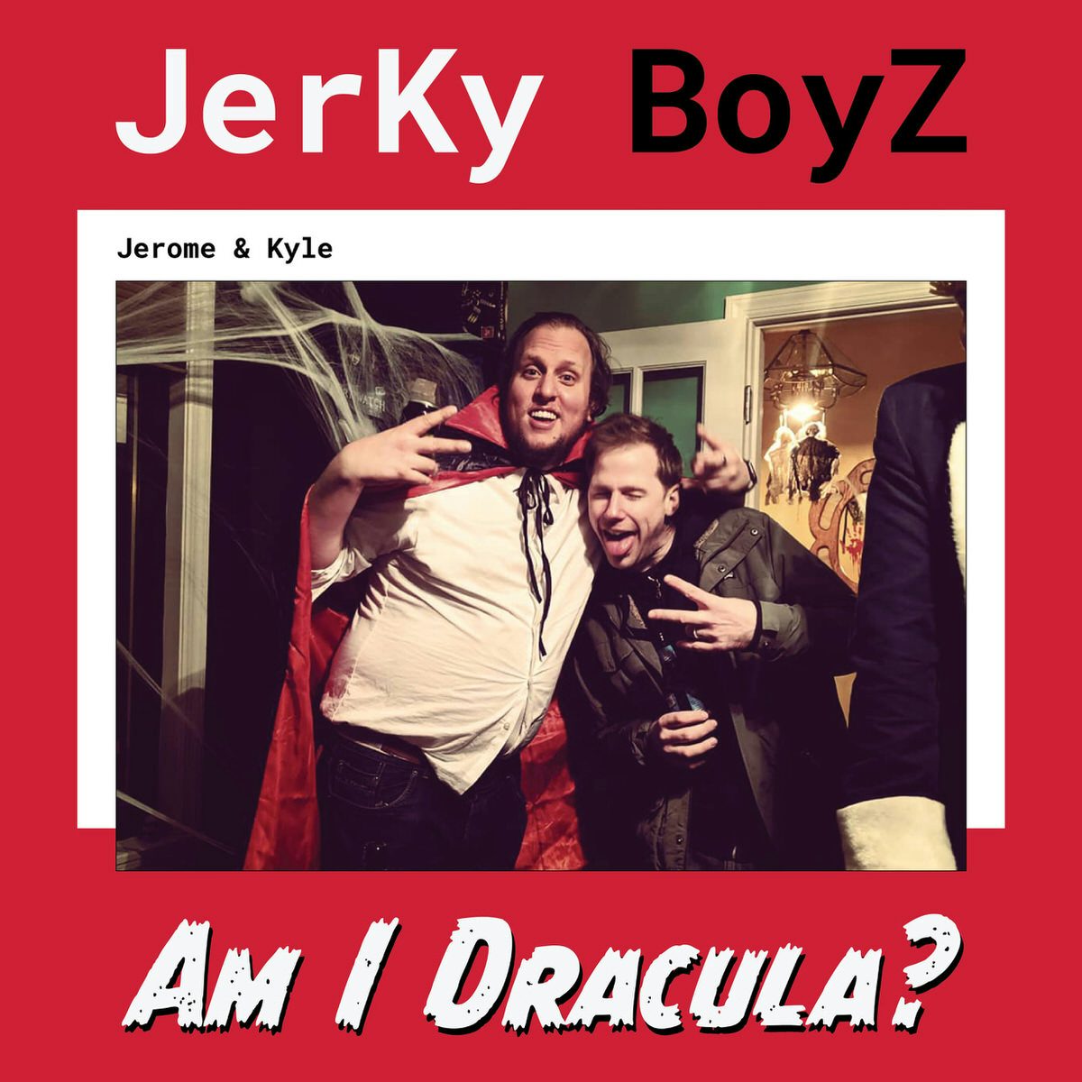 The Album Cover of “Am I Dracula?” A photo Jer & Ky as they embrace and throw up peace signs. Ky is on the left dressed as Dracula complete with cape. Jerome has a beer in hand and a regular coat. There are cob-webs behind them as this look to be a Halloween party and Jerome did not know.